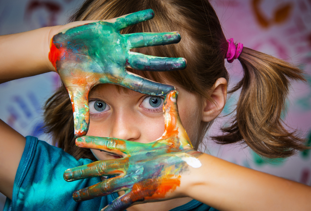 IMAGE: Young white girl with painted hands.